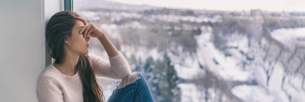 seasonal affective disorder: Sad Woman With Seasonal Disorder Girl Grief Stricken Alone At Home Window Thinking Negative Thoughts Mental Health Banner Panorama Background