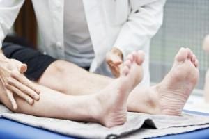 Doctor touching legs for pain